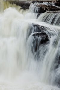 The serene Tad Lo waterfall crashing over large rocks, located in the Bolaven Plateau which was named after the Laven ethnic group which has historically dominated the region.